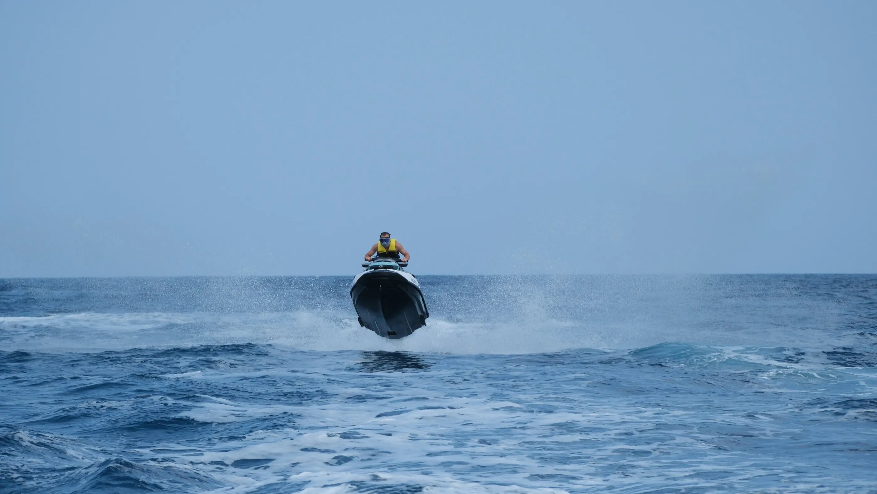 A rider on a jet ski coming head-on over open sea