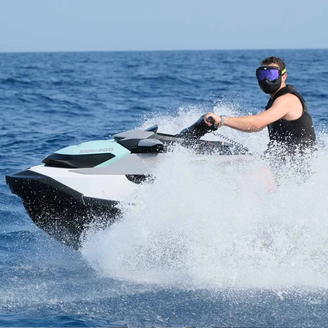 Rider in Black Onyx cutting through spray on a jet ski