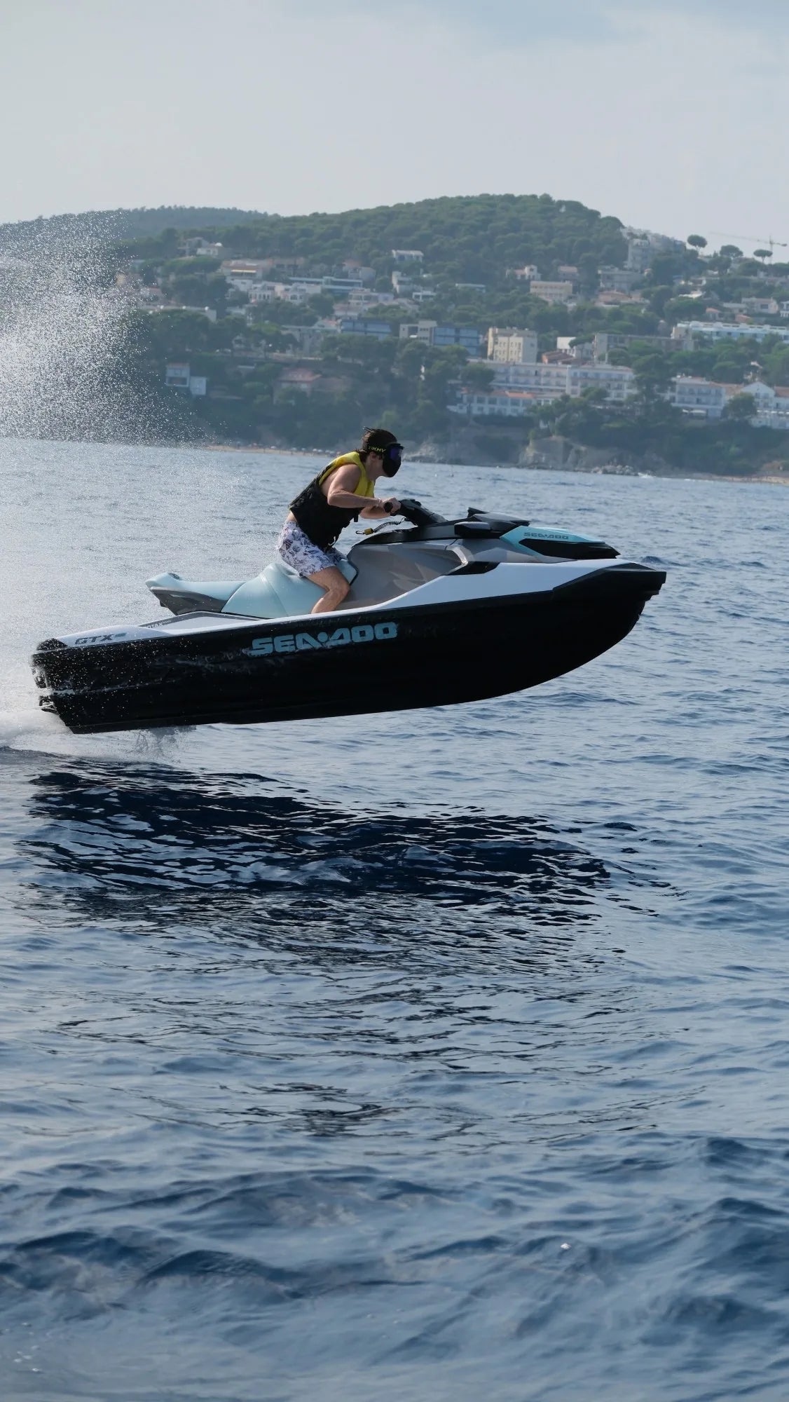 Jet ski in mid-air off a wave; the rider’s MASKHY Wavy in Black Onyx stays in place